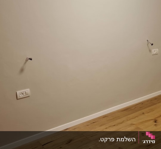 התקנת פרקט בדוגמת עץ עם פנלים לבנים לאורך הקיר